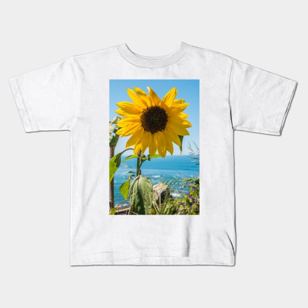 Sunflower field. Sunflower with blue sky and the sea in backgorund. Summer background, bright yellow sunflower over blue sky. Landscape with sunflower field over cloudy blue sky. Kids T-Shirt by AnaMOMarques